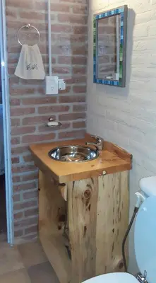 a bathroom with a wooden sink and a toilet at Piedramadre hermosa cabaña a metros del río hasta 4 huéspedes in Cordoba