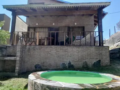 a small green pond in front of a house at Piedramadre hermosa cabaña a metros del río hasta 4 huéspedes in Cordoba