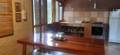 a kitchen with a wooden table and a refrigerator at Piedramadre hermosa cabaña a metros del río hasta 4 huéspedes in Cordoba