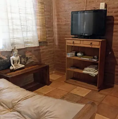 a living room with a television on a wooden stand at Piedramadre hermosa cabaña a metros del río hasta 4 huéspedes in Cordoba