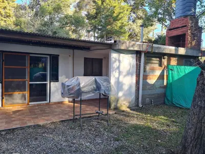a house with a screened in porch next to a building at Cabañas los Nonitos in Villa Los Aromos