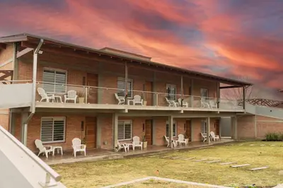 a building with chairs and a balcony with a sky at Apart de Sierras in Nono