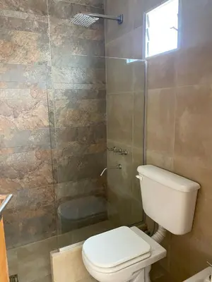 a bathroom with a toilet and a glass shower at Apart de Sierras in Nono
