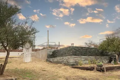 a stone wall with a sign in a yard at Apart de Sierras in Nono