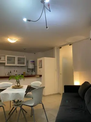 a living room with a table and chairs and a kitchen at Departamento en Nueva Cordoba in Cordoba