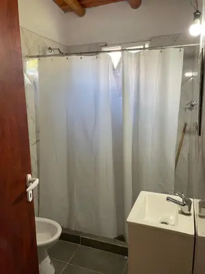 a bathroom with a shower and a sink and a toilet at Cabañas D Noris in Los Hornillos