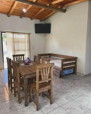 a dining room with a wooden table and chairs at Cabañas D Noris in Los Hornillos