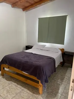 a bedroom with a large bed with a large window at Cabañas D Noris in Los Hornillos