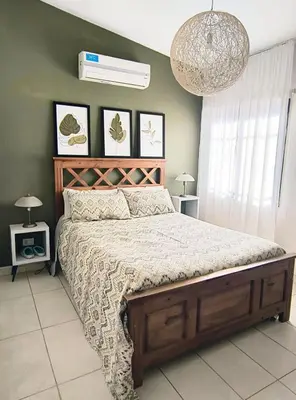 a bedroom with a large bed and a chandelier at Casa Privada Carlos Paz con piscina a dos cuadras del rio in Villa Carlos Paz
