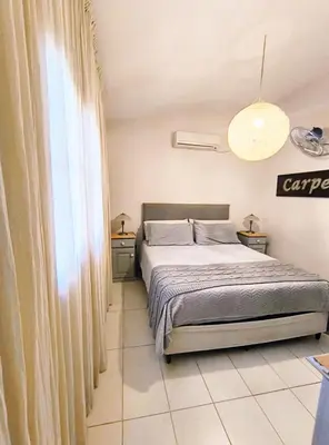 a bedroom with a bed and a large window at Casa Privada Carlos Paz con piscina a dos cuadras del rio in Villa Carlos Paz