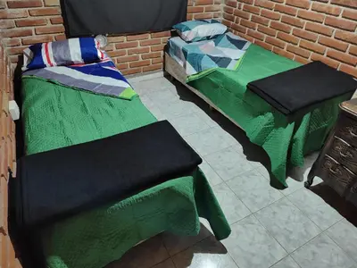 two beds sitting next to a brick wall at Amables 2 in Salsacate