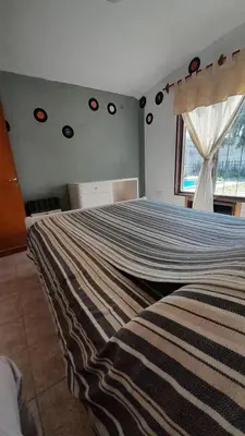 a bedroom with a large bed with a striped blanket at Departamento Nini Villa Del Dique in Villa del Dique