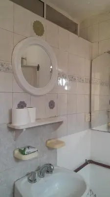 a bathroom with a sink and a mirror and a tub at Departamento Nini Villa Del Dique in Villa del Dique