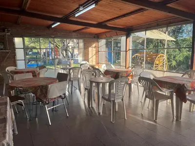 an empty restaurant with tables and chairs and windows at HueneyRuca in Mina Clavero