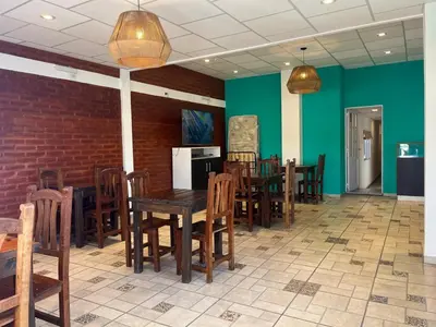a dining room with wooden tables and chairs and green walls at HueneyRuca in Mina Clavero