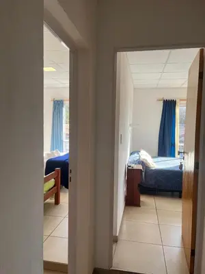 a hallway with a room with two beds and a mirror at HueneyRuca in Mina Clavero