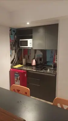 a kitchen with a stove and a microwave at Departamento 114 - Edificio VILAUT by INMOVE Temporarios in Cordoba