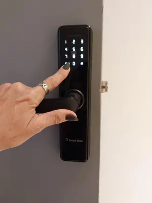 a person holding a remote control on a door at Departamento Glamour 203 - Edificio VILAUT by INMOVE Temporarios in Cordoba