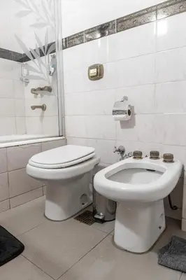 a bathroom with a toilet and a bidet at Departamento Glamour 203 - Edificio VILAUT by INMOVE Temporarios in Cordoba