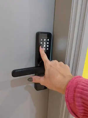 a person holding a cell phone in a door handle at Departamento 216 - Edificio VILAUT by INMOVE Temporarios in Cordoba