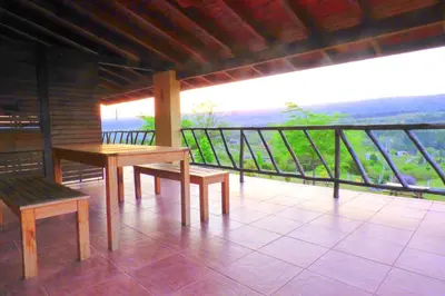 a table and benches on a balcony with a view at Complejo Terrazas al Champaqui in Villa Yacanto