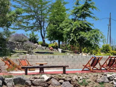two chairs and a picnic table in a garden at Complejo Terrazas al Champaqui in Villa Yacanto