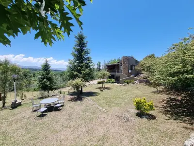 a park with a bench and a building at Complejo Terrazas al Champaqui in Villa Yacanto
