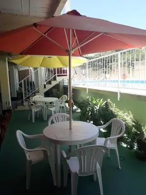 a table and chairs with umbrellas on a balcony at Altos del Plata in Villa Carlos Paz