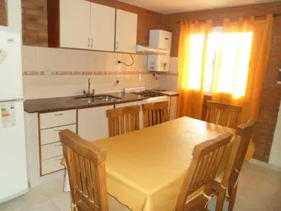 a kitchen with a table and chairs and a sink at Altos del Plata in Villa Carlos Paz
