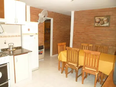 a kitchen and dining room with a yellow table and chairs at Altos del Plata in Villa Carlos Paz