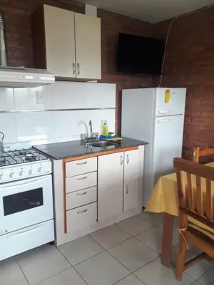 a kitchen with white cabinets and a white refrigerator at Altos del Plata in Villa Carlos Paz
