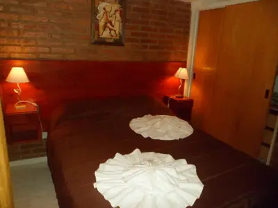 a hotel room with a bed with two white sheets at Altos del Plata in Villa Carlos Paz