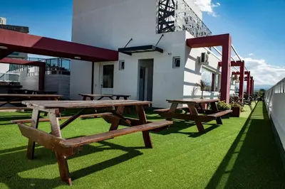a group of picnic tables sitting on the grass at Departamento céntrico de 2 habitaciones y Pileta Edificio Sommet in Villa Carlos Paz