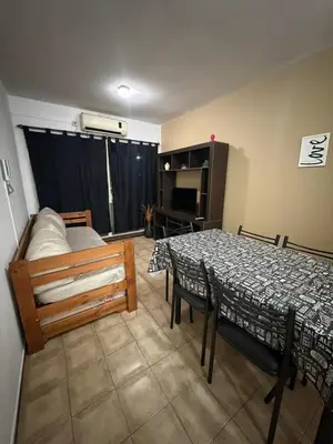 a room with a table and a bed and a bedroom at Depto Morandini in Villa Carlos Paz