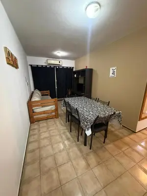 a dining room with a table and chairs in a room at Depto Morandini in Villa Carlos Paz