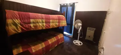 a bedroom with a bed and a fan and a window at Depto Morandini in Villa Carlos Paz