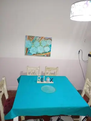a blue table with two chairs and a painting on the wall at El Dpto de Gabicito III in Cordoba