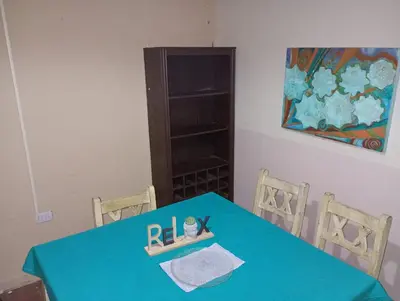 a blue table with two chairs and a shelf at El Dpto de Gabicito III in Cordoba