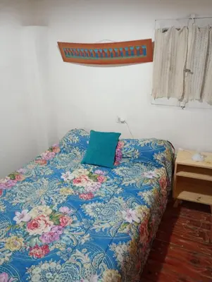 a bed in a room with a blue blanket and a pillow at El Dpto de Gabicito III in Cordoba