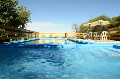 a swimming pool with a fence and a table and chairs at Corazon de Montaña in Merlo