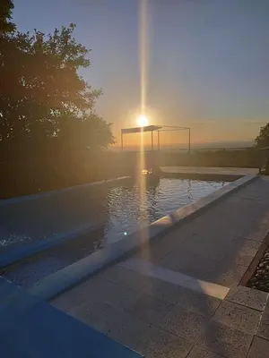 a sun setting over a swimming pool with a goal at Corazon de Montaña in Merlo