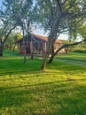 a red barn with a tree in front of it at Corazon de Montaña in Merlo