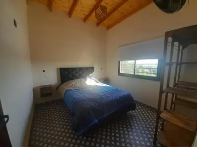 a bedroom with a bed with a blue comforter at Cabañas R&E in Mina Clavero