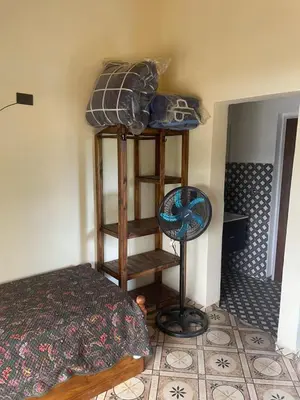a bedroom with a bed and a fan in a room at Cabañas R&E in Mina Clavero