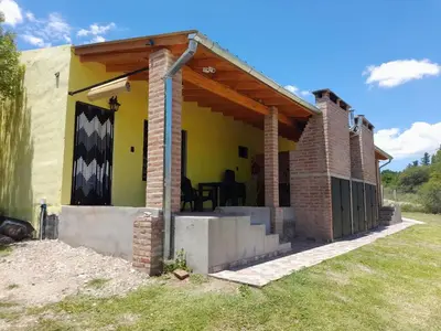 a house with a porch with a roof at Cabañas R&E in Mina Clavero