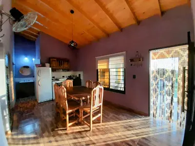 a kitchen and dining room with a table and chairs at Cabañas R&E in Mina Clavero