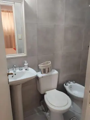 a bathroom with a white toilet and a sink at Temporario Alberdi in Cordoba