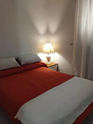 a bedroom with a red and white bed with a lamp at Temporario Alberdi in Cordoba