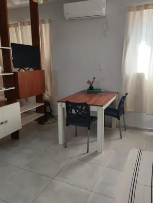 a living room with a wooden table and chairs at Temporario Alberdi in Cordoba