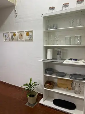 a white shelf with glasses and plates and a plant at Dpto confortable, super equipado para 4 huéspedes y cerca de todo! in Cordoba
